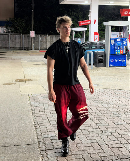 Person walking on a sidewalk at a gas station during nighttime.