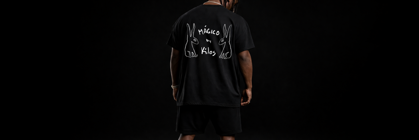 Person wearing a black t-shirt with a graphic design on the back against a black background